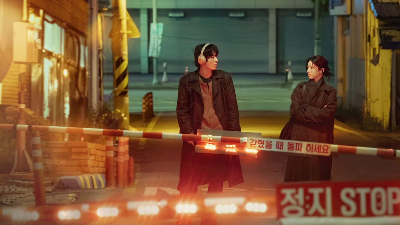 Imagem oficial da série: Koo Kyo-hwan com fones de ouvido e Go Youn-jung de braços cruzados diante de uma cancela de passagem de nível à noite