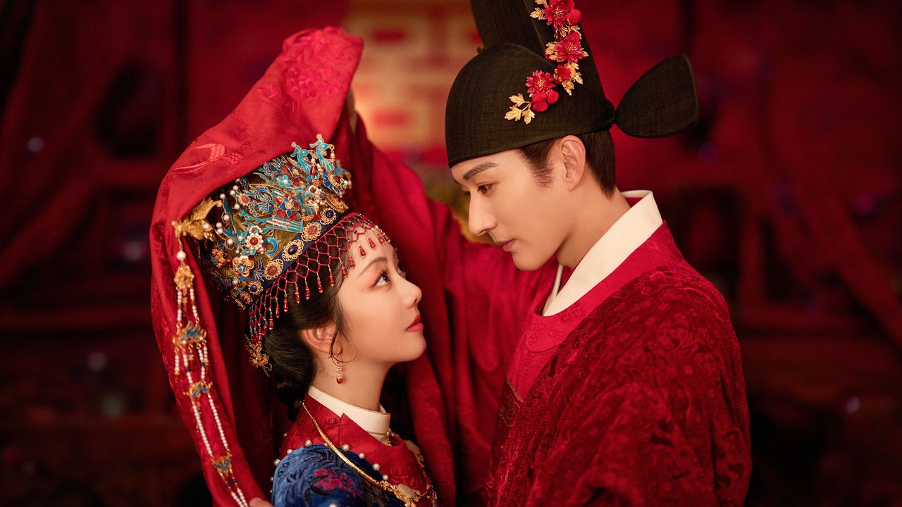 Tan Song Yun de véu vermelho e coroa dourada de noiva olha para Liu Xue Yi, de chapéu preto e roupa vermelha, em arte oficial da série