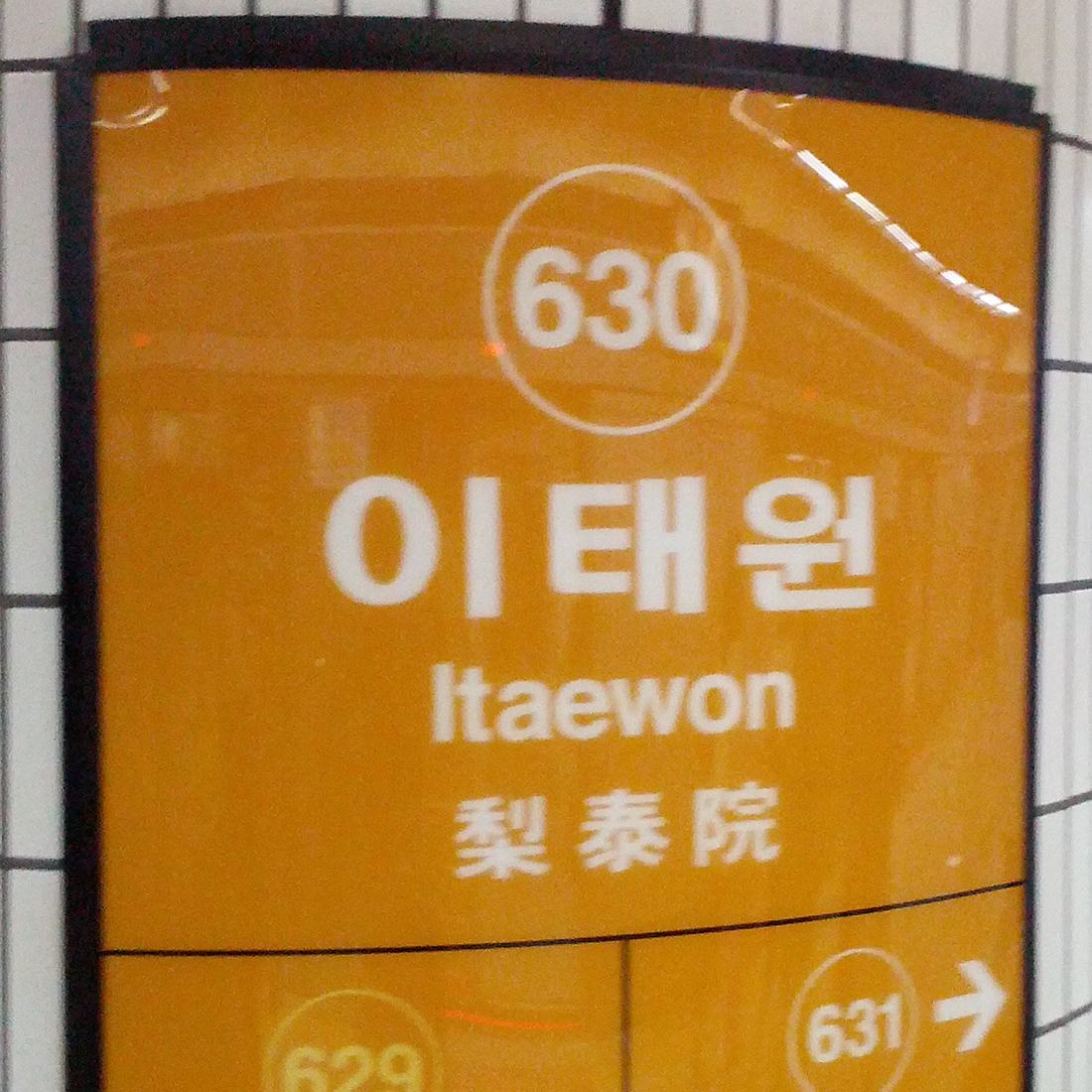 Placa de estação com o nome Itaewon escrito em hangul, em letras latinas e em hanja, com o número da estação