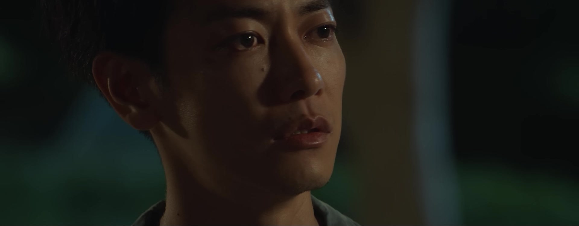 Close de um homem de cabelo curto, de três quartos, em luz baixa, em quadro do trailer oficial de First Love, da Netflix