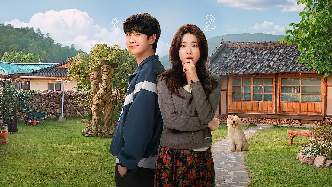 Jung Hae-in, de jaqueta esportiva azul, e Ha Young, de cardigã cinza e saia florida com a mão no queixo, num quintal gramado com casa tradicional, totens de madeira e um cachorro branco peludo