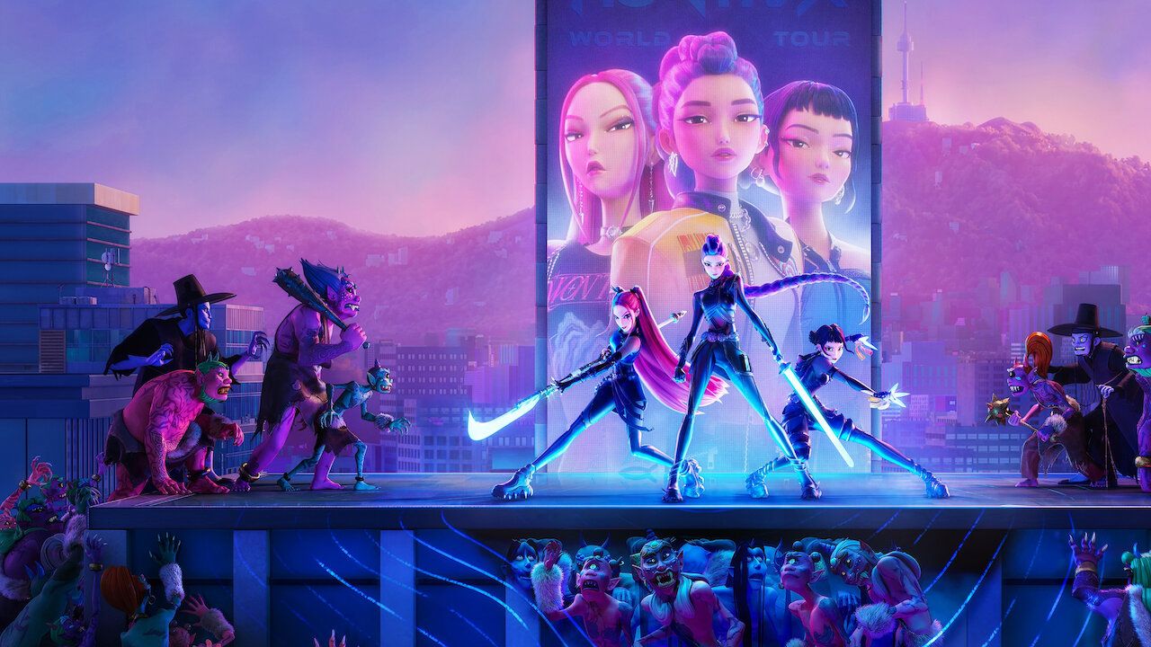 Arte de divulgação de Guerreiras do K-Pop na Netflix: três personagens animadas de espada em punho sobre um palco no alto de um prédio, diante de um painel luminoso com três rostos animados e o texto World Tour, monstros dos dois lados e uma plateia de monstros embaixo, com montanhas e uma torre ao fundo no fim da tarde