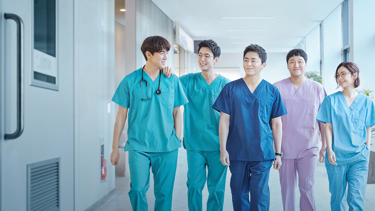 Arte de divulgação de Hospital Playlist na Netflix: cinco pessoas de uniforme cirúrgico em verde-água, azul-marinho, lilás e azul-claro, uma delas com estetoscópio, caminhando e sorrindo num corredor de hospital