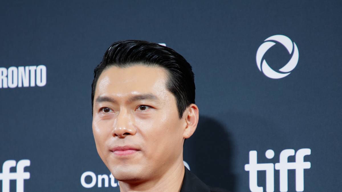 Hyun Bin de terno escuro sorri num evento do Festival Internacional de Cinema de Toronto