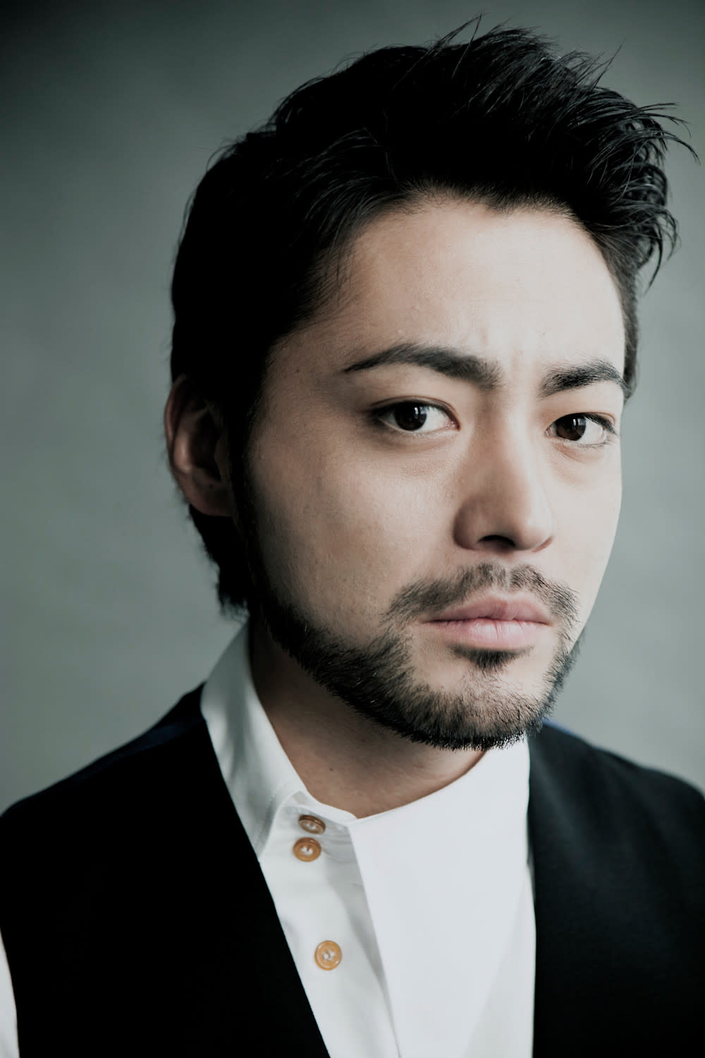 Retrato de Takayuki Yamada com barba, camisa clara e paletó escuro